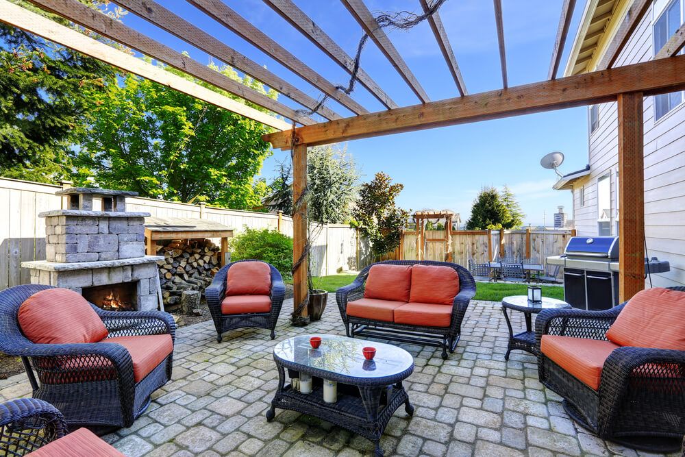 Backyard cozy patio area with wicker furniture set and brick fireplace