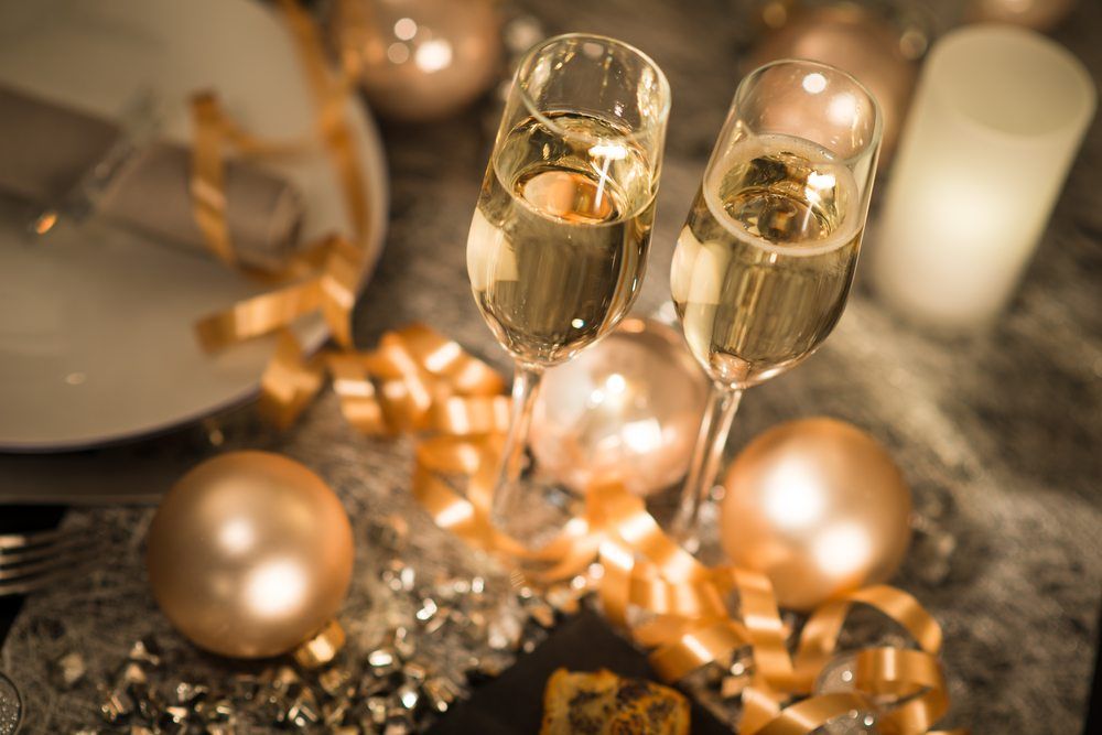 new years eve party table with champagne flute ribbon and golden glitter