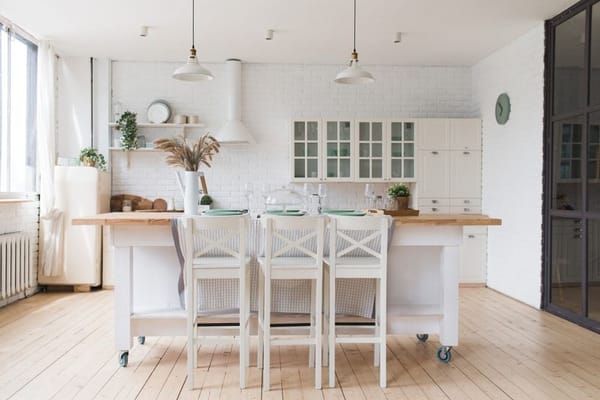 Cuisine d'inspiration scandinave avec tabourets de bar en bois, appareils électroménagers blancs, îlot de cuisine