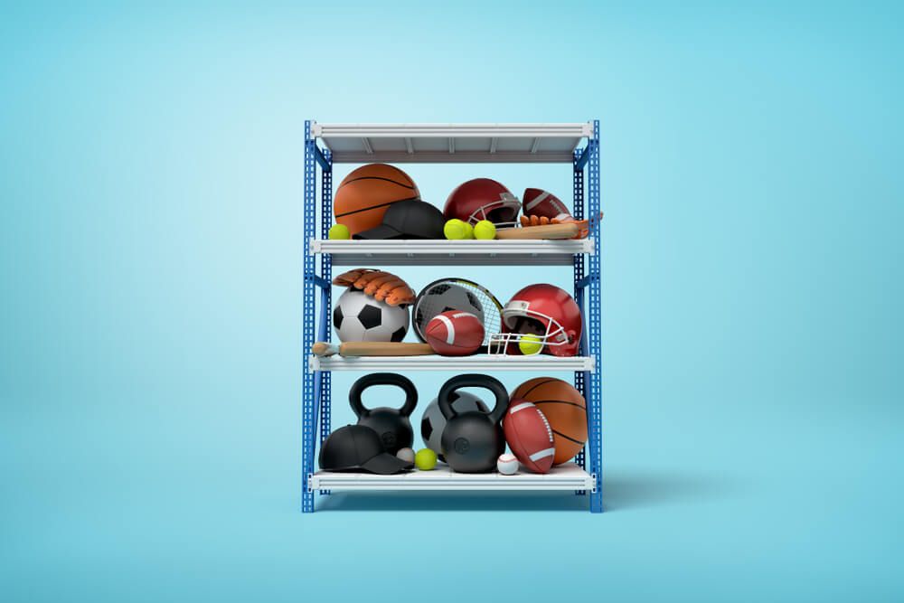 Various balls, bats and helmets stored on shelving racks