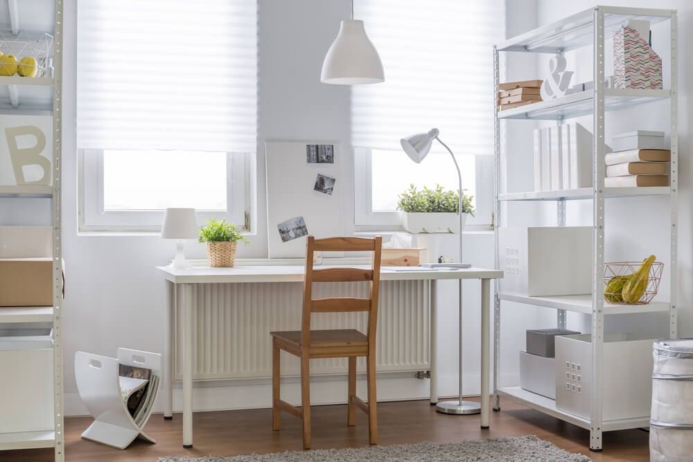 Study room with a table and chair, shelves and carpet